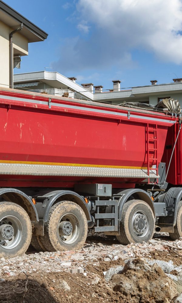 Truck on construction site. Trucking on construction concept. Tipper loaded with concrete bricks, building site. For construction theme illustrating.